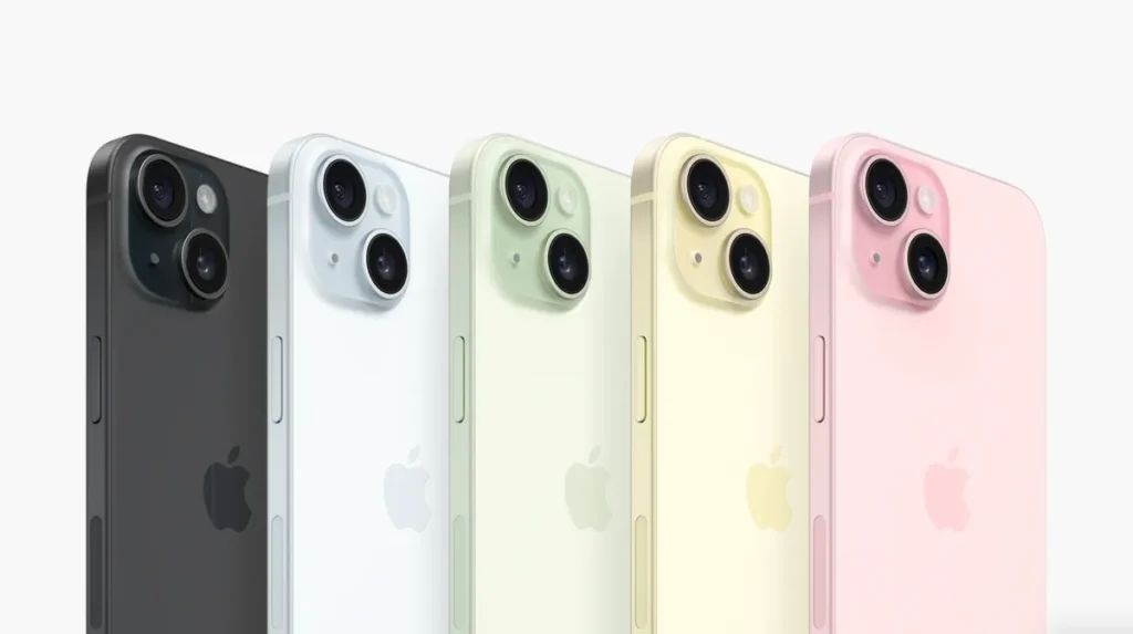 Řada iPhone 15 v barvách černá, bílá, zelená, žlutá a růžová se zaměřením na dvojité zadní kamery.