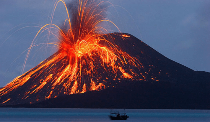 Noční výjev erupce sopky Mauna Loa s vyvrhujícími se oblouky lávy a jasně oranžovým svitem odrážejícím se v hladině oceánu, zatímco malá loď pluje v popředí.