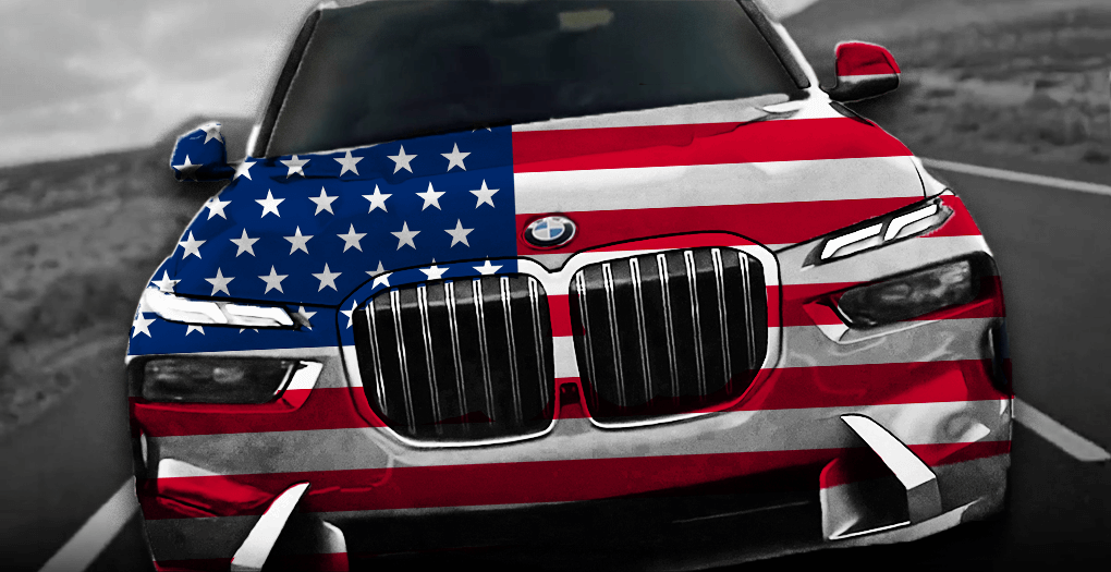 BMW vyrobené v EU, pokryté americkou vlajkou, na silnici symbolizující nižší ceny v USA oproti ČR.