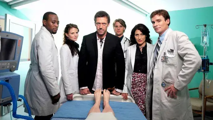 Fotka seriálu Dr.House - v čele Dr. Gregory House spolu se svým týmem lékařů stojí kolem pacienta na nemocničním lůžku. Zleva doprava: Dr. Eric Foreman, Dr. Allison Cameron, Dr. Gregory House, Dr. Robert Chase, Dr. Lisa Cuddy a Dr. James Wilson.