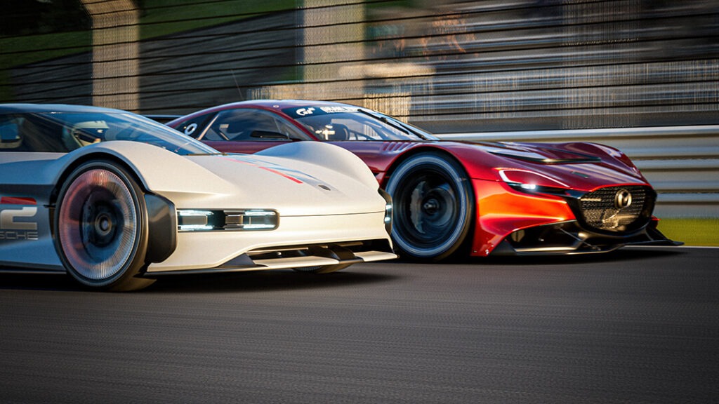 Dva konceptní závodní vozy, bílý Porsche a červené Mazda, v ostrém závodě na simulovaném okruhu ve hře Gran Turismo 7, zachycené v pohybu