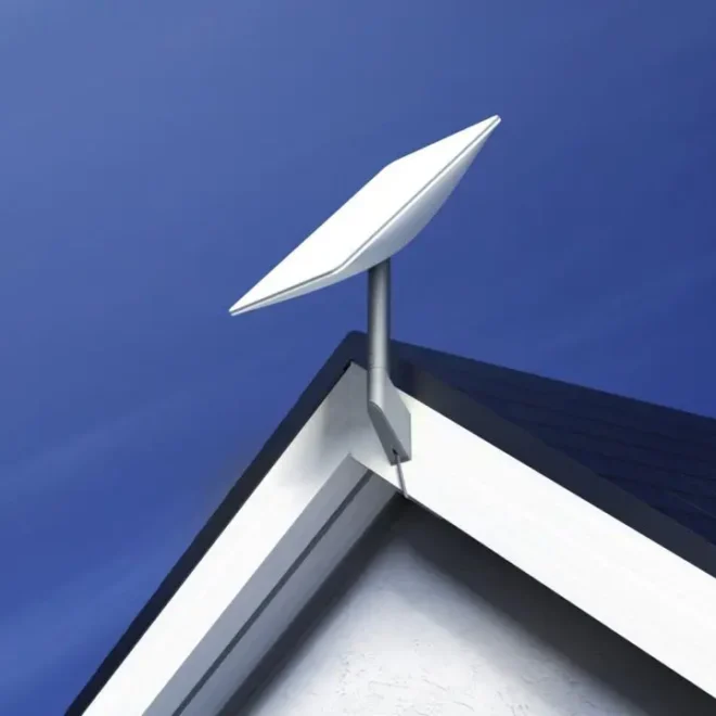 Starlink satelitní anténa na střeše domu proti modré obloze