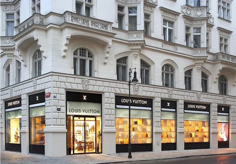 Luxusní butik Louis Vuitton v Pařížské ulici v Praze, umístěný v elegantní historické budově s krásnou architekturou.