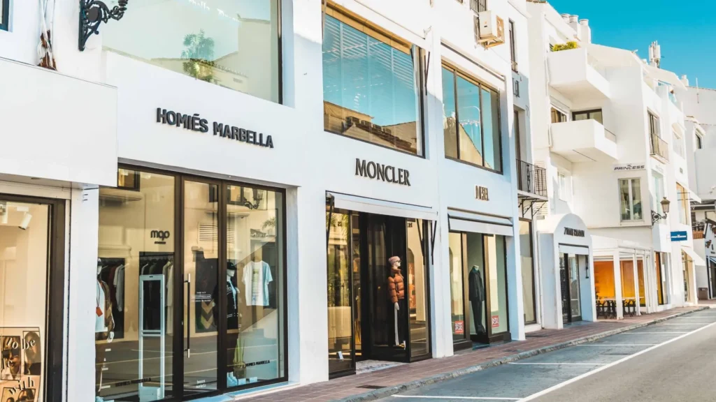 Obchody a nakupování v Marbelle s luxusními butiky jako Moncler a Homies Marbella. Elegantní nákupní třída s moderními výlohami a stylovými obchody, ideální pro milovníky módního nakupování a exkluzivních značek.