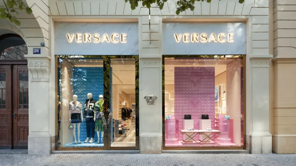 Vnější pohled na luxusní butik Versace v Pařížské ulici v Praze, s elegantními výlohami vystavujícími módní kolekce.