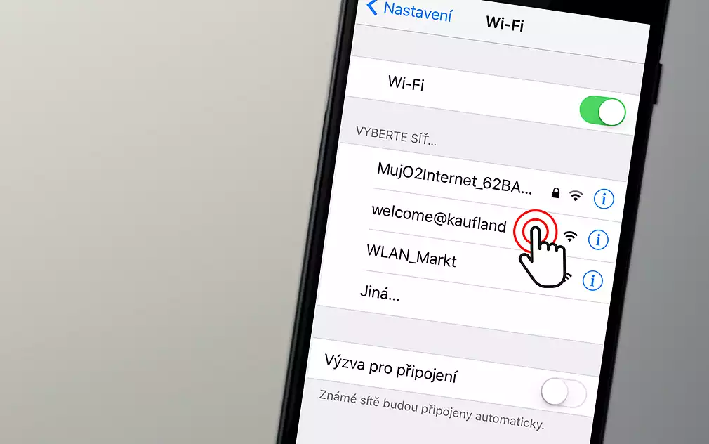 Fotografie zachycuje obrazovku mobilního telefonu, na které jsou zobrazeny dostupné WiFi sítě v nastavení. Vidíme několik různých sítí, mezi nimi například „MujO2Internet_62BA...“ (zabezpečená), „welcome@kaufland“ (veřejná) a „WLAN_Markt“. U sítě „welcome@kaufland“ je ikona ukazující na ni prstem, naznačující, že se jedná o síť, kterou si uživatel může vybrat. V horní části obrazovky je vidět zapnutý přepínač WiFi. Texty jsou v češtině, což naznačuje, že se telefon nachází v prostředí, kde je český jazyk hlavním komunikačním jazykem.