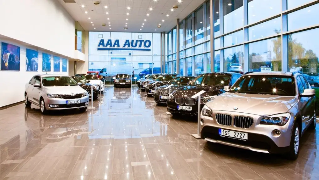 Interiér autosalonu AAA AUTO s vystavenými ojetými vozy různých značek, včetně BMW a Škoda.