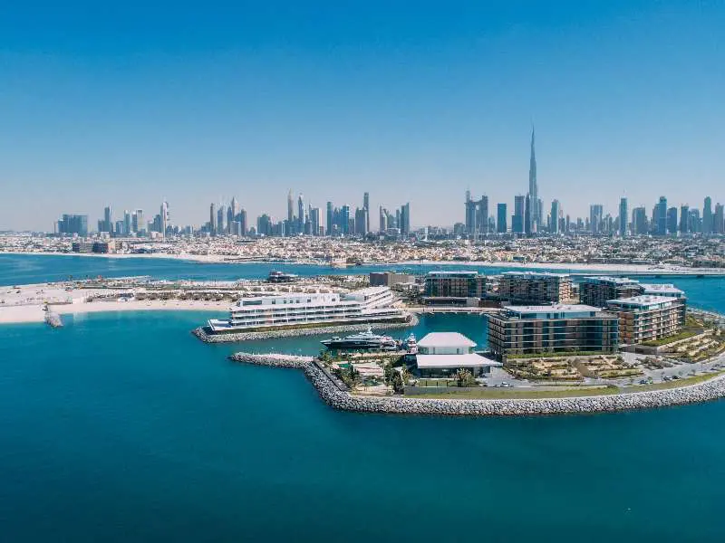 Letecký pohled na Bulgari Resort Dubai, luxusní resort nacházející se na soukromém ostrově ve tvaru mořského koníka, s panoramatickým výhledem na Dubaj.