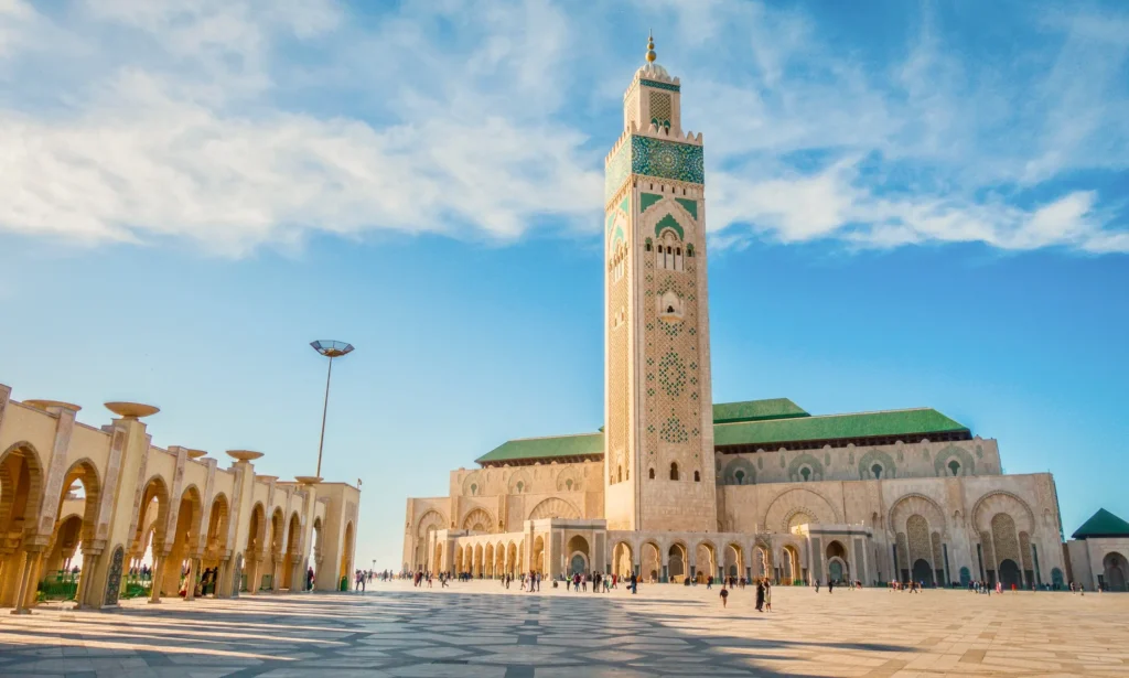 Mešita Hassana II. v Casablance, Maroko, s vysokým minaretem a prostorným nádvořím pod modrou oblohou.