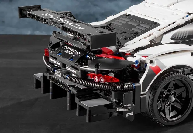 Detail zadní části LEGO® Technic Porsche 911 RSR s viditelným zadním křídlem a difuzorem, které dodávají modelu aerodynamický vzhled.