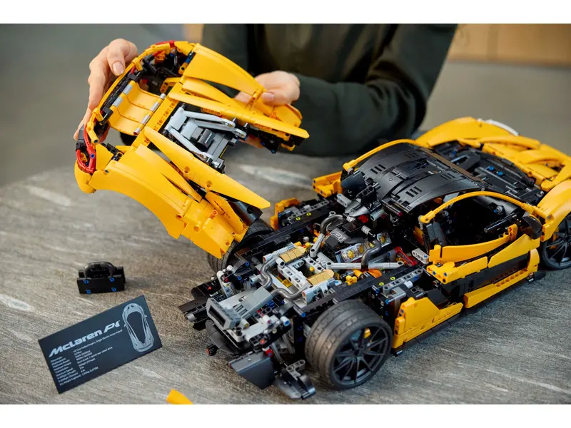 Detailní pohled na rozložený model LEGO® Technic McLaren P1™ při montáži, s odnímatelnými částmi karoserie a pístovým motorem.