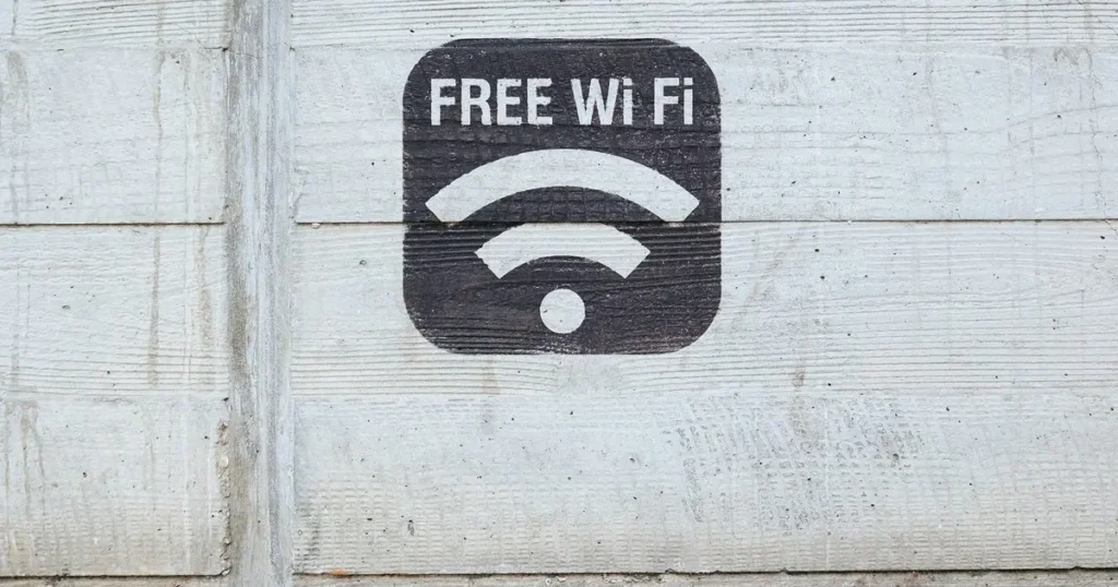 Značka „Free Wi-Fi“ namalovaná na betonové zdi, upozorňující na dostupnost bezplatného připojení k internetu.