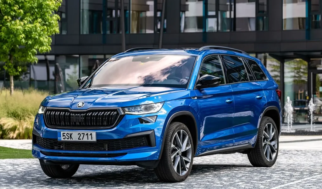 Modrá Škoda Kodiaq RS zaparkovaná před moderní budovou, zobrazující její elegantní design a robustní vzhled SUV.