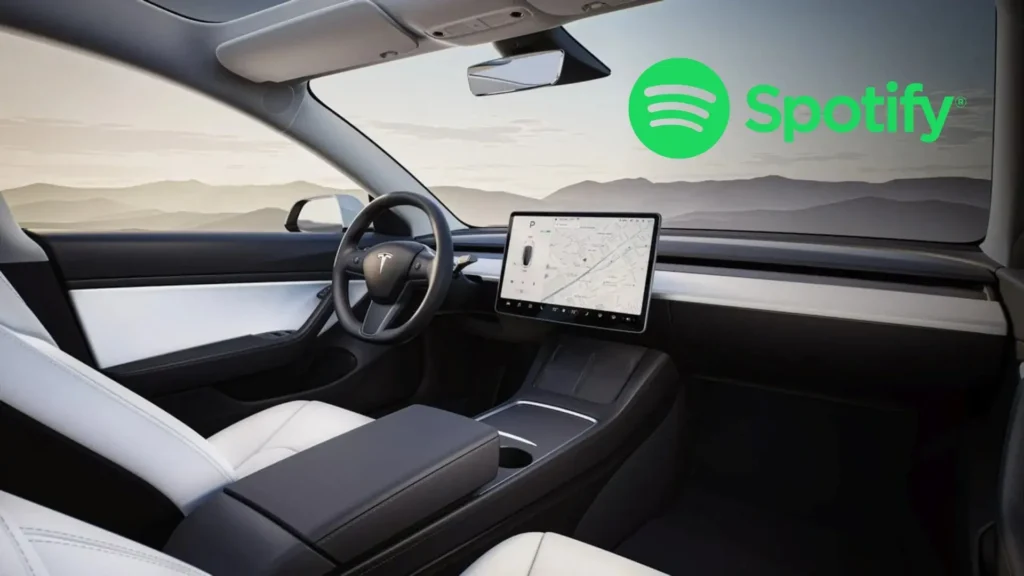 Interiér vozu Tesla Model Y s centrálním displejem a logem Spotify, zobrazující minimalistický a moderní design s pohodlnými sedadly a velkou dotykovou obrazovkou.