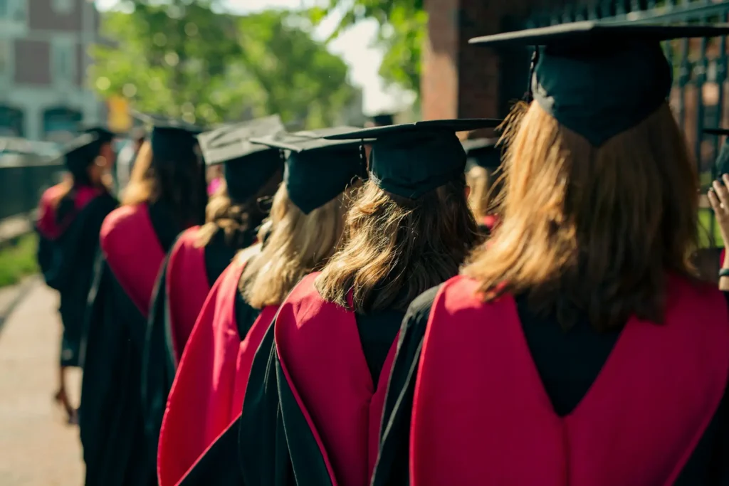 Studenti v tradičních akademických talárech během promoce na prestižní univerzitě.