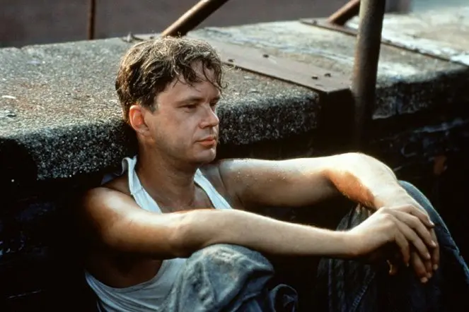 Andy Dufresne odpočívá na střeše věznice, ponořený do myšlenek o naději a svobodě.