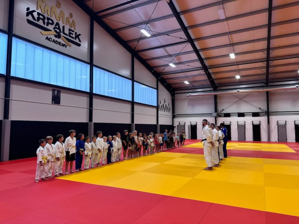 Tréninková hala Krpálek Academy s dětmi na tatami při slavnostním nástupu.