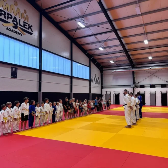 Tréninková hala Krpálek Academy s dětmi na tatami při slavnostním nástupu.