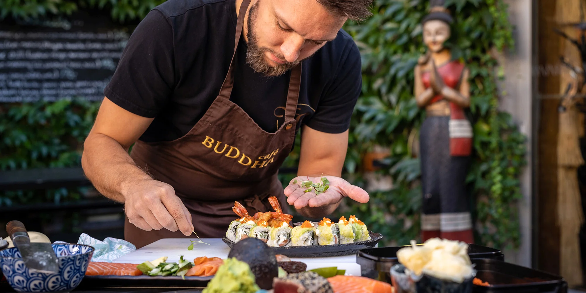 Kurz přípravy sushi ve Škole vaření Café Buddha, kde šéfkuchař připravuje sushi s čerstvými surovinami.