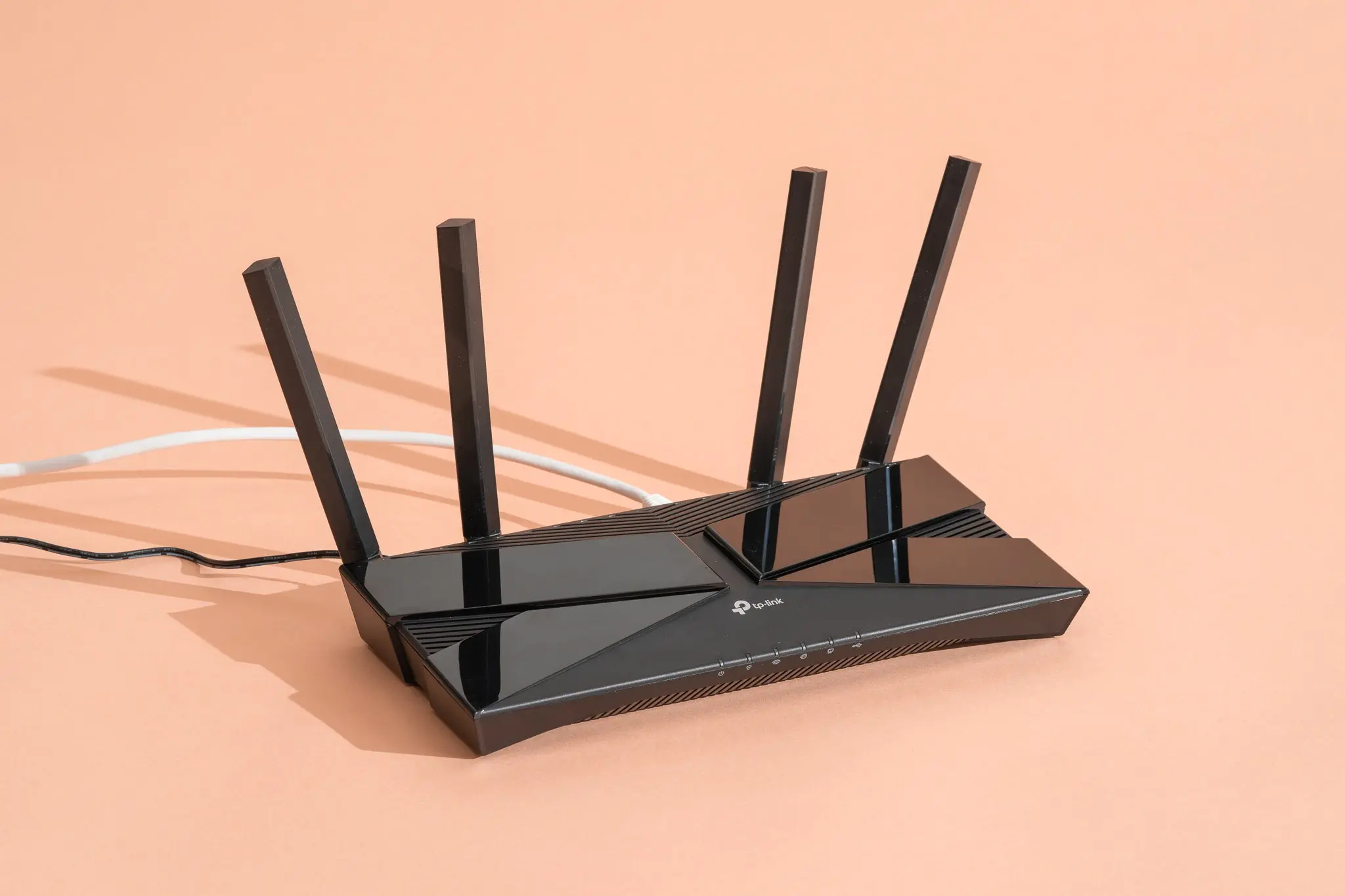 Detailní pohled na moderní Wi-Fi router s čtyřmi anténami, ideální pro široké pokrytí signálem v domácnosti nebo kanceláři.