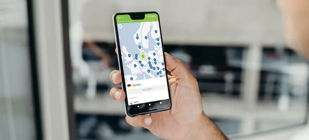 Ruka drží smartphone s otevřenou aplikací VPN, která zobrazuje mapu serverů v Evropě a aktuální připojení k serveru v Německu.