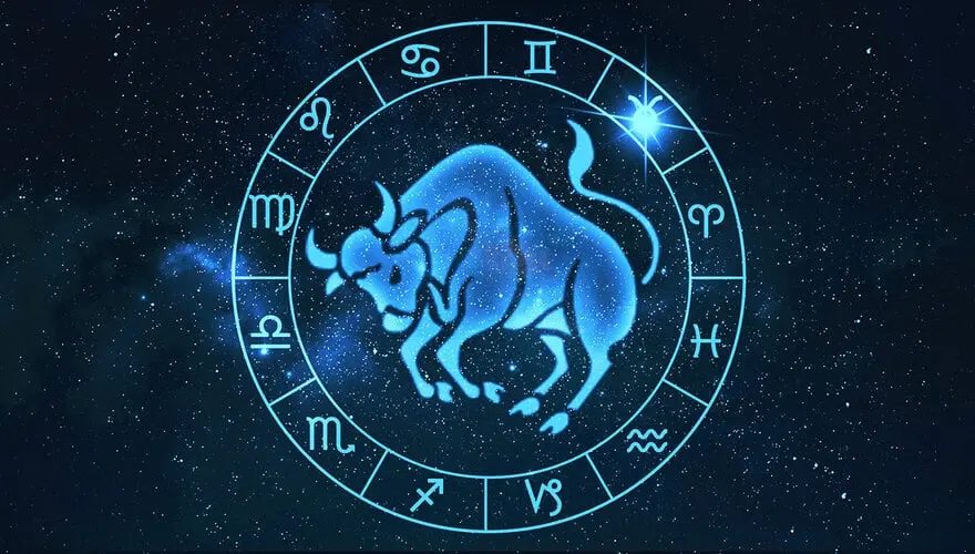 Modře zářící znamení zvěrokruhu Býk obklopené astrologickým kruhem s dvanácti symboly ostatních znamení, zasazené do hvězdné noční oblohy.