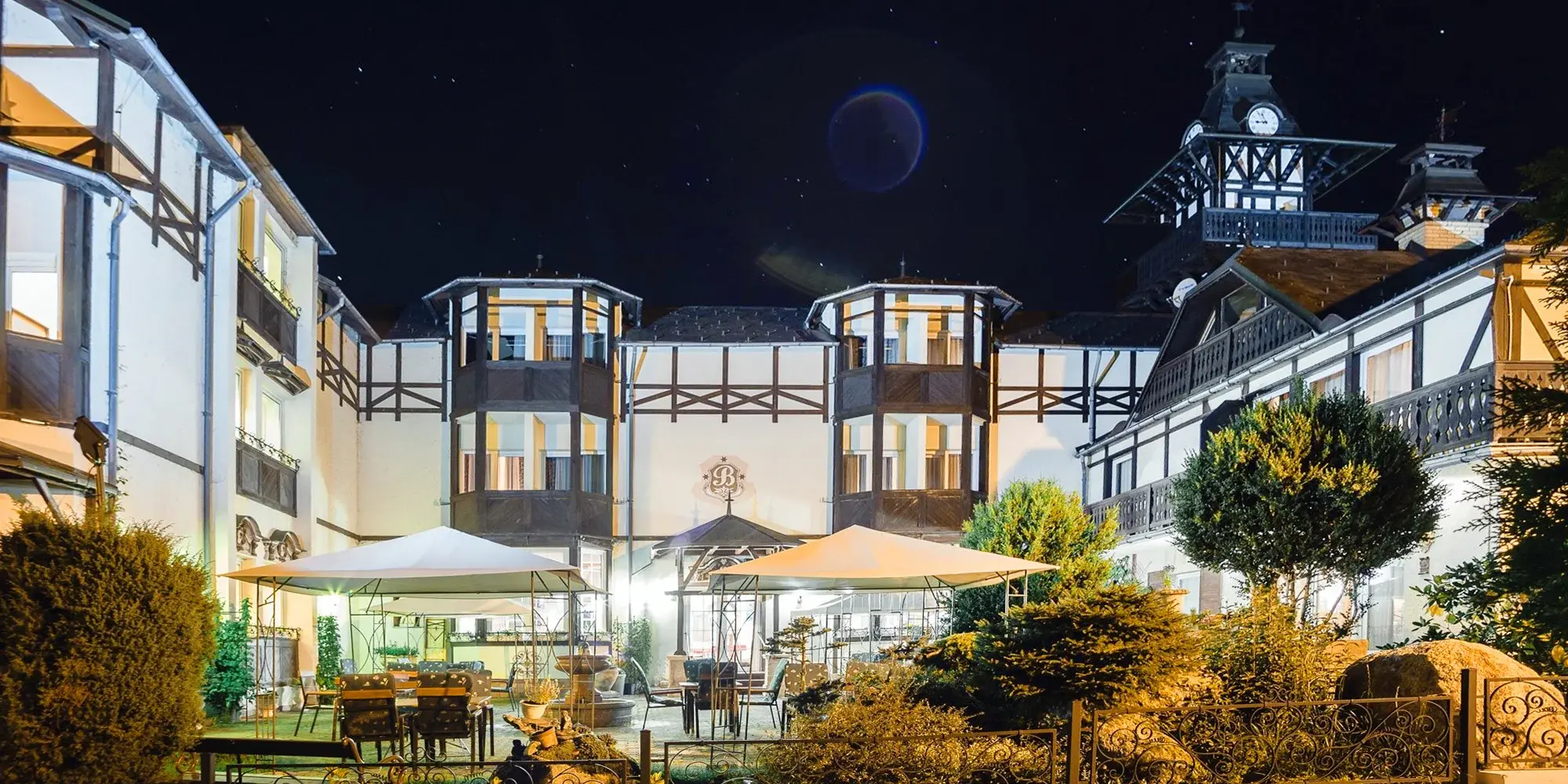 Nádherný hotel v klidné části Mariánských Lázní, s nočním osvětlením a romantickou atmosférou, obklopený zahradou.