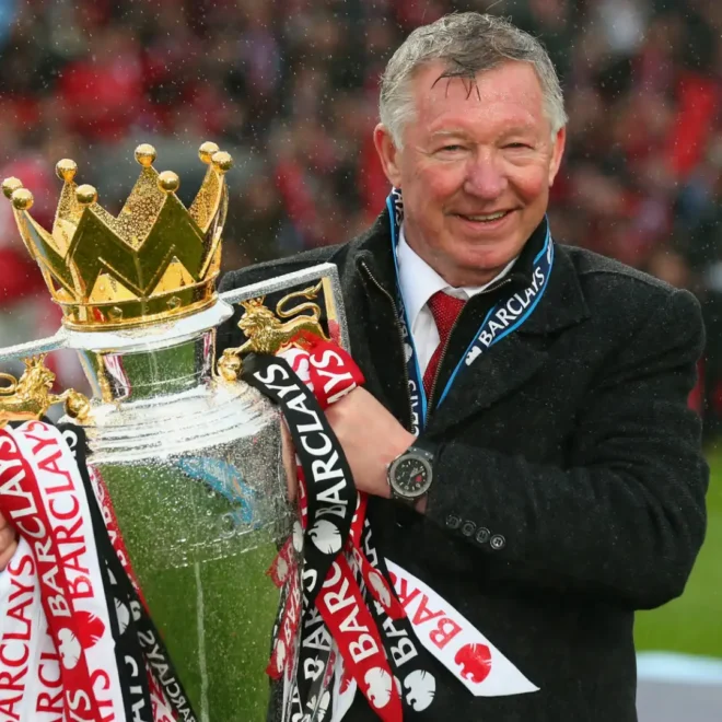 Alex Ferguson s trofejí Premier League, symbolizující jeho úspěšnou trenérskou kariéru.