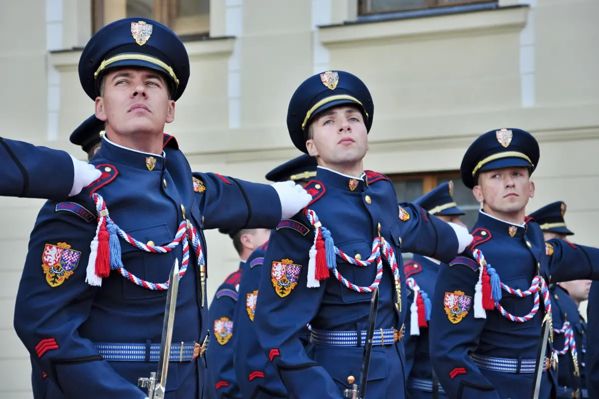 Členové Hradní stráže v elegantních uniformách při slavnostní přehlídce na Pražském hradě.