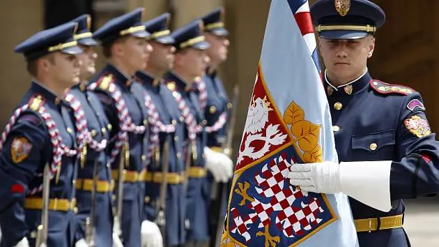 Členové Hradní stráže v elegantních uniformách při slavnostní přehlídce na Pražském hradě.