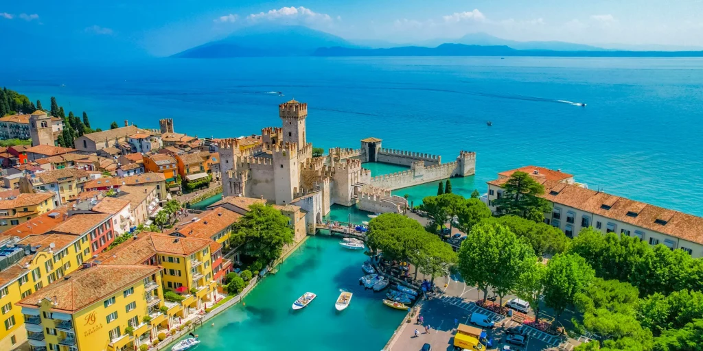 Malebné městečko Sirmione na břehu jezera Lago di Garda s historickým hradem Rocca Scaligeri.