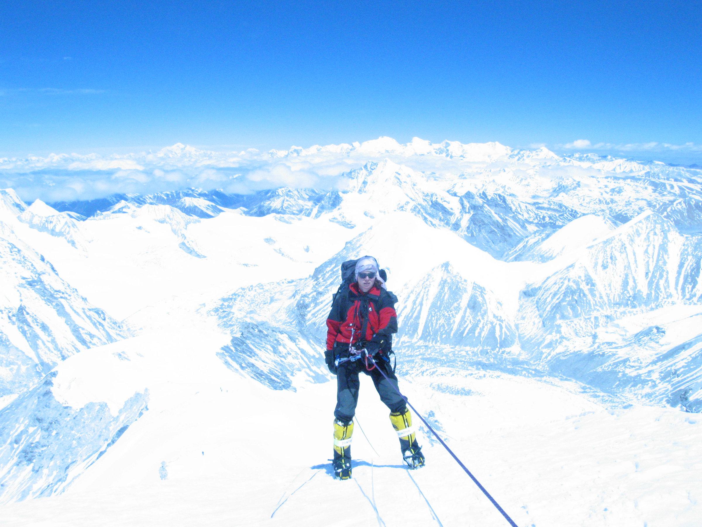 Klára Kolouchová při výstupu na Cho Oyu, s nádherným panoramatem zasněžených hor v pozadí. Zdroj obrázku: web Klára Kolouchová