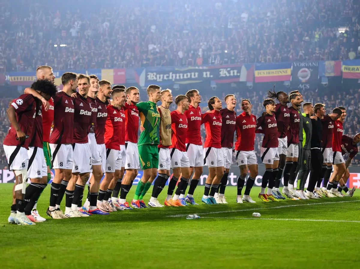 Hráči fotbalového klubu Sparta Praha oslavují postup v Lize mistrů UEFA 2024/2025 před fanoušky na zaplněném stadionu.