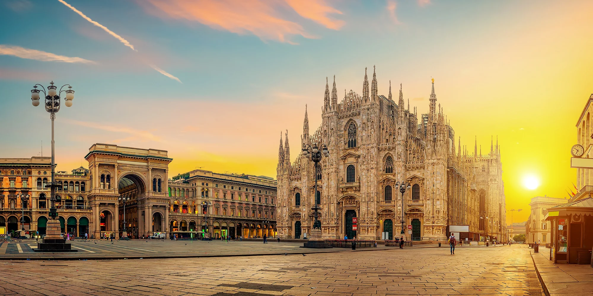 Slavná milánská katedrála Duomo při západu slunce na náměstí Piazza del Duomo.