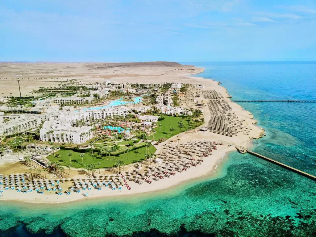 Letecký pohled na hotelový komplex Pickalbatros Palace Port Ghalib v Marsa Alam, obklopený bazény, zelenými zahradami a soukromou pláží u azurového moře.