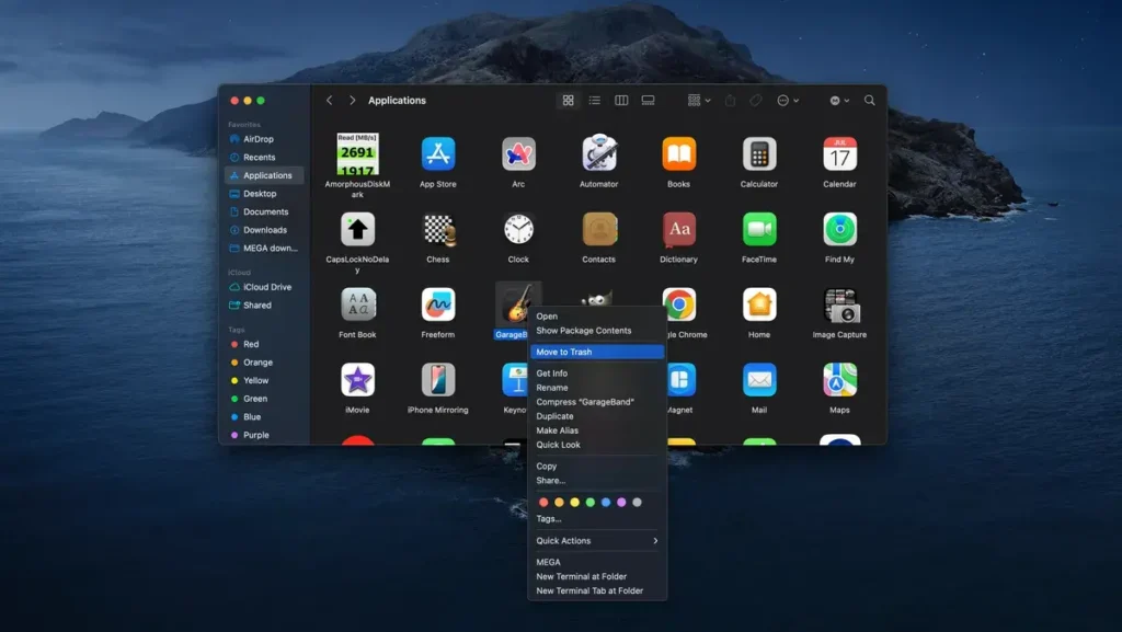 Snímek obrazovky Finderu na Macu v tmavém režimu se složkou Aplikace. Uživatel kliknul pravým tlačítkem na aplikaci GarageBand a vybral možnost 'Přesunout do koše' pro její odstranění.