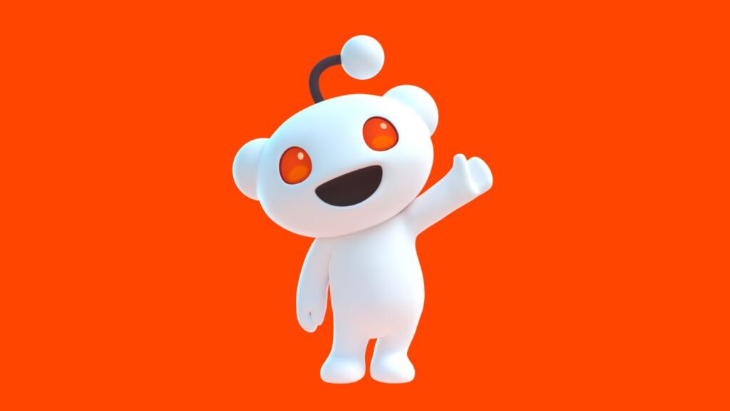 Maskot Redditu s červenýma očima na oranžovém pozadí, symbolizující komunitní a diskusní platformu.