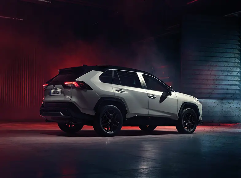 Toyota RAV4 v nočním městském prostředí s dramatickým osvětlením