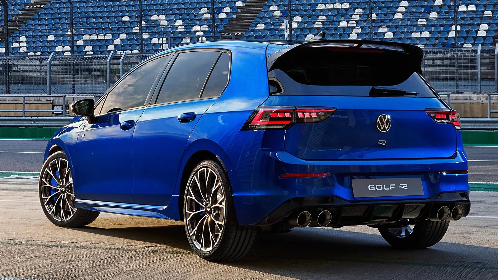 Modrý Volkswagen Golf R zachycený zezadu na závodním okruhu, s výrazným zadním spoilerem a čtveřicí výfuků.