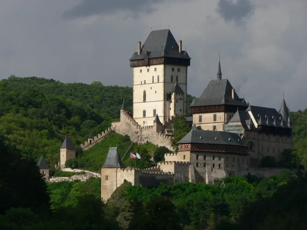 Hrad Karlštejn obklopený zelenými lesy, impozantní gotická stavba ve středních Čechách.