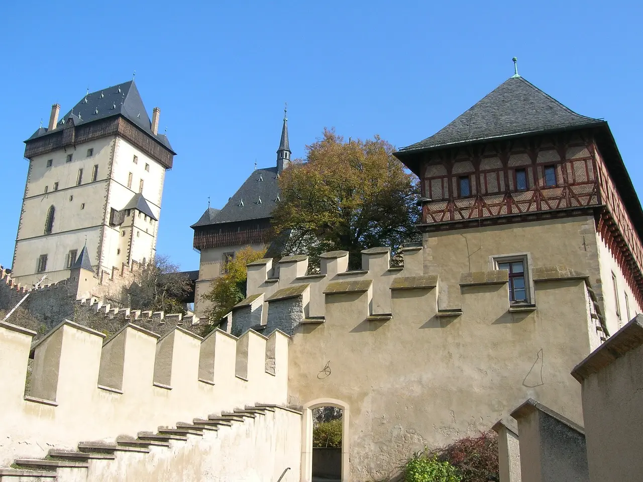 Nádvoří hradu Karlštejn, kde můžete obdivovat impozantní architekturu věží a zdí ze 14. století.